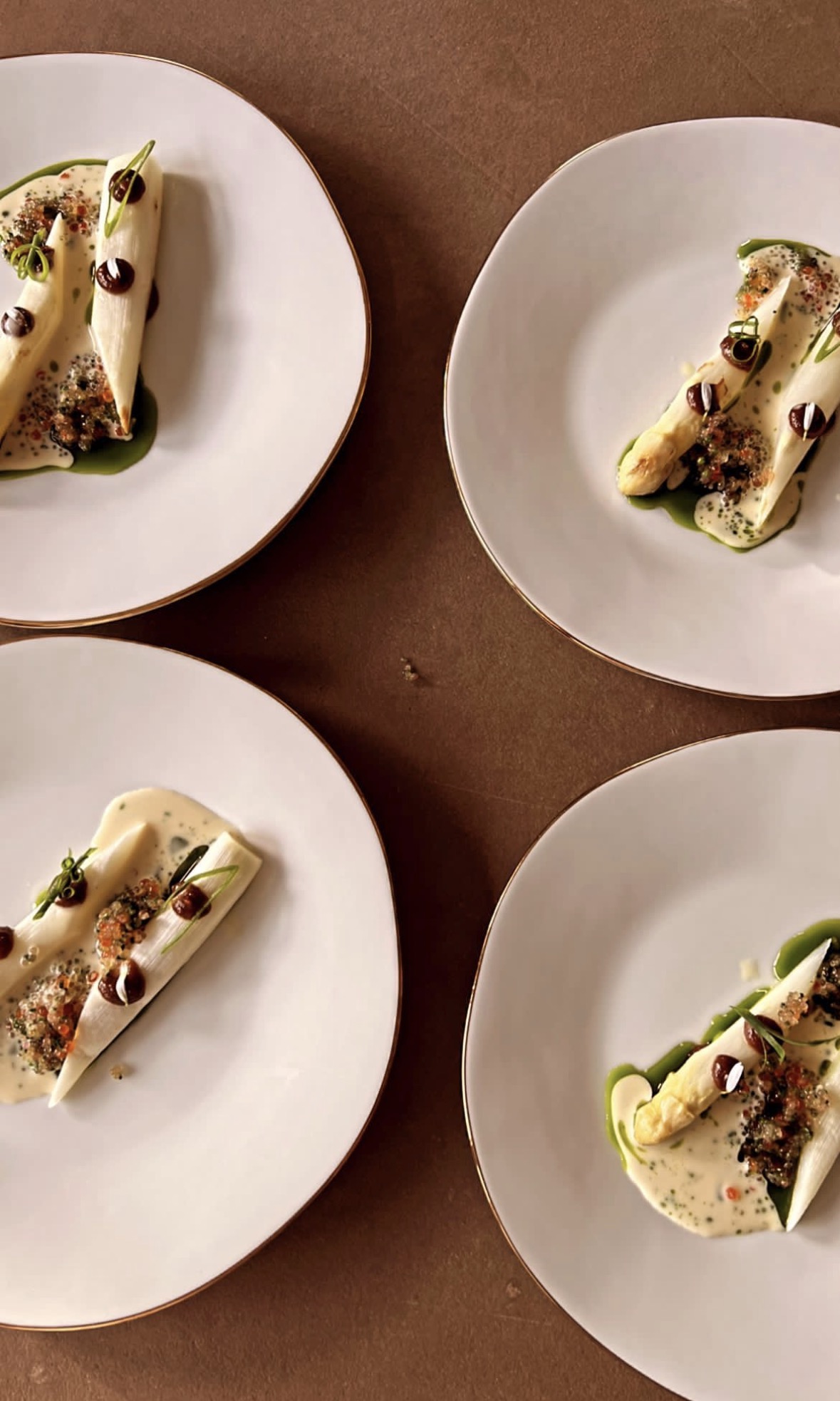 White asparagus plated with herbs and caviar